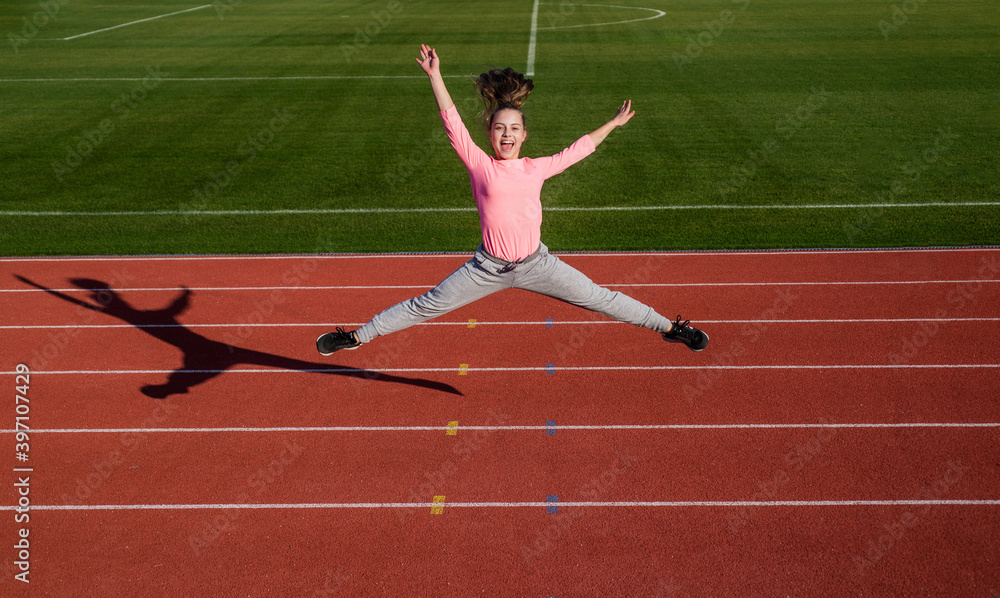girl kid jump high outside on stadium arena, energy