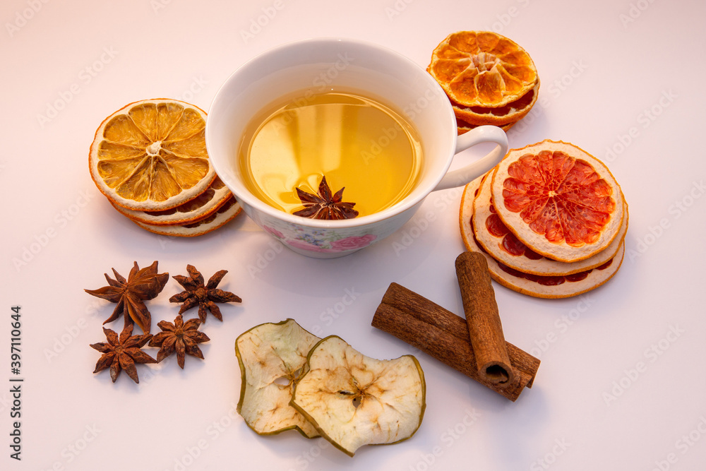 Creative layout of tea cup with dried fruits, cinnamon and anise stars Creative layout of tea cup with dried fruits, cinnamon and anise stars