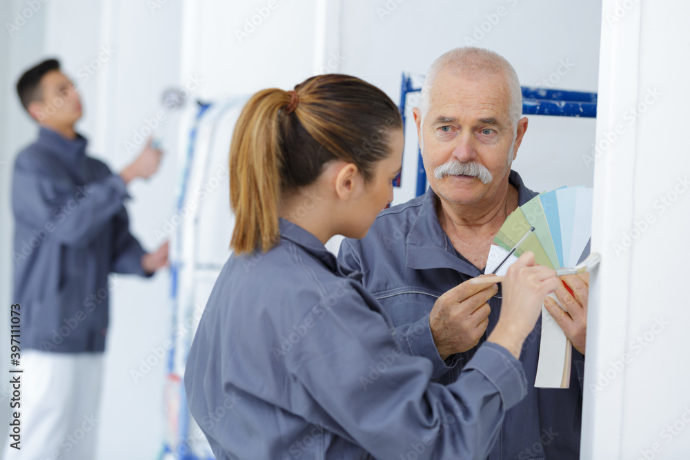 Obraz premium painting and decorating colleagues looking at colour samples