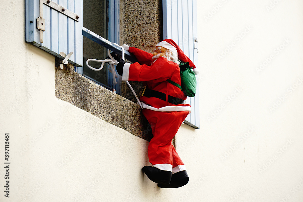 Foto de Père noel grimpant à la fenêtre . do Stock Adobe Stock