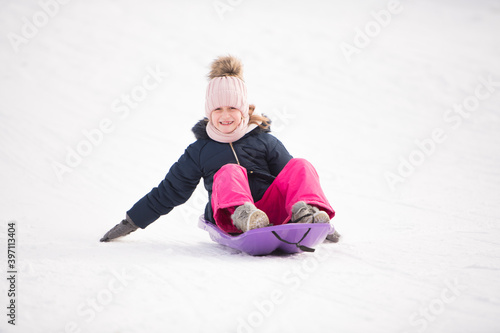 une petite fille fait de la luge