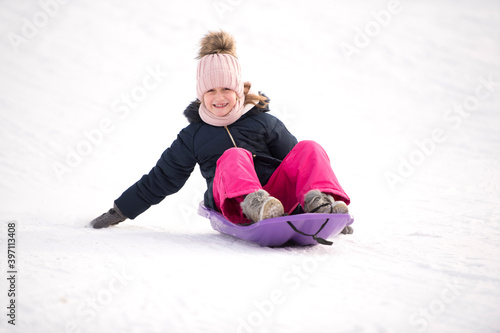 une petite fille fait de la luge