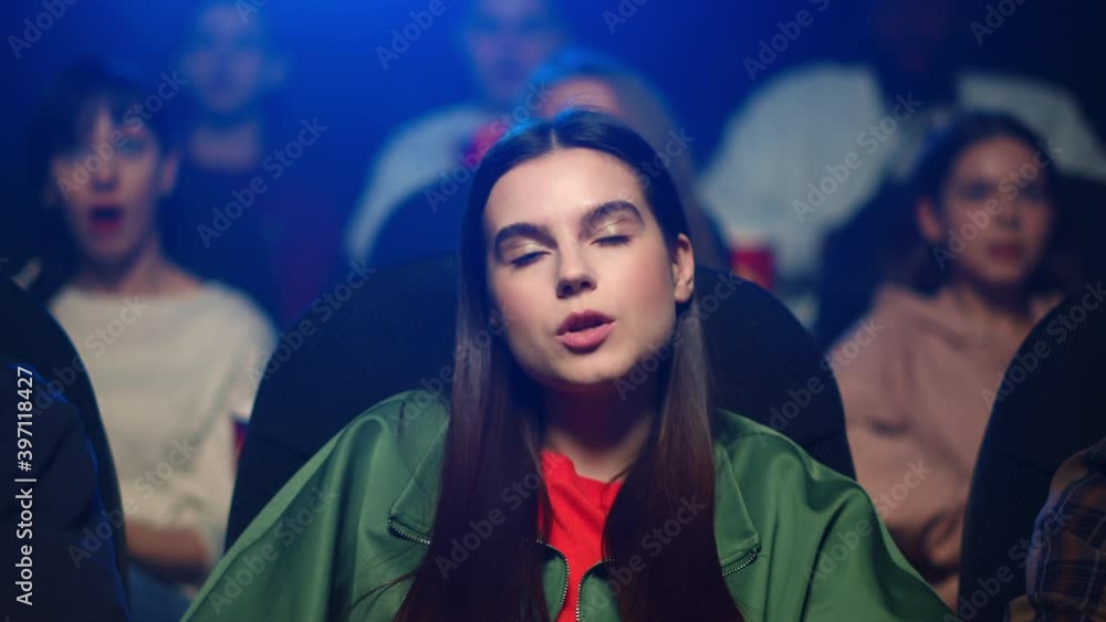Focused woman watching movie in cinema. Cute girl spending time in movie theater Focused woman watching movie in cinema. Cute girl spending time in movie theater