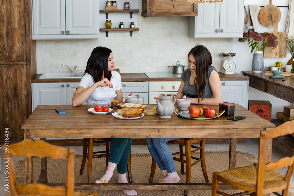 © Елизавета Лукашевич - Two girls are drinking tea with cake and sweets at the table.
