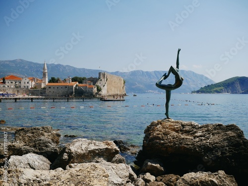 Sculpture of a dancer against the background of the old town of Budva 