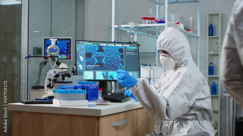 Chemist with coverall looking at virus test in equipped lab. Scientist working with various bacteria, tissue and blood samples, concept of pharmaceutical research for antibiotics against covid19 Chemist with coverall looking at virus test in equipped lab. Scientist working with various bacteria, tissue and blood samples, concept of pharmaceutical research for antibiotics against covid19