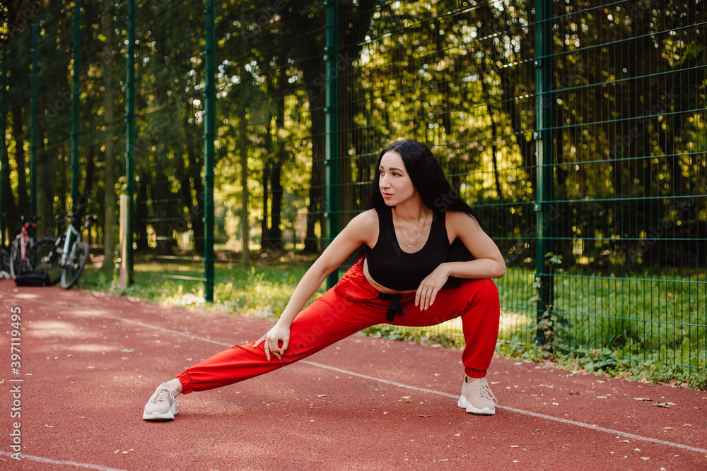 Fitness sport girl in fashion sportswear doing yoga fitness exercise in the street, outdoor sports, urban style