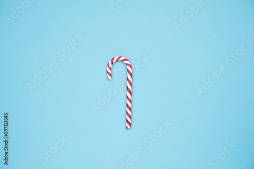 Christmas red candy cane on blue background. Merry Christmas sweets and Minimal Happy New Year concept