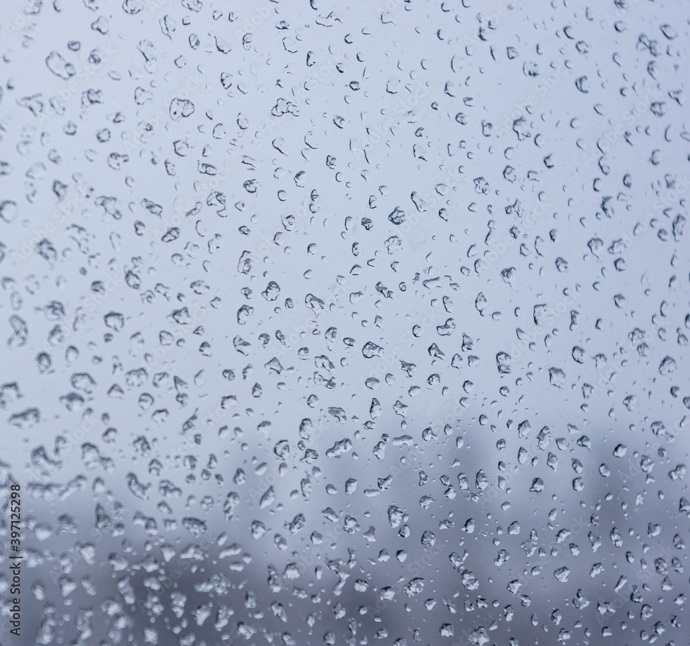Melting snow on the glass, drops of water condensation on the window, and transparent glass of the window in cold winter, winter landscape outside the window, close-up. Melting snow on the glass, drops of water condensation on the window, and transparent glass of the window in cold winter, winter landscape outside the window, close-up.