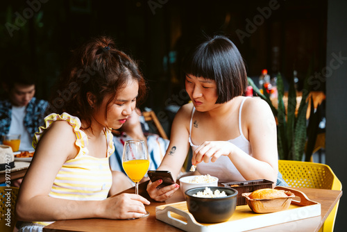 Two young asian women looking at smartphone.