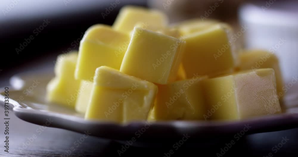 Cubes of butter on a plate being picked up Cubes of butter on a plate being picked up