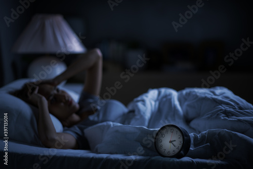 Depressed young woman lying in bed cannot sleep from insomnia photo