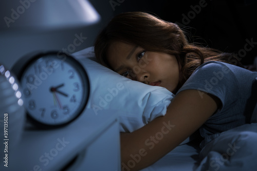 Depressed young woman lying in bed cannot sleep from insomnia photo