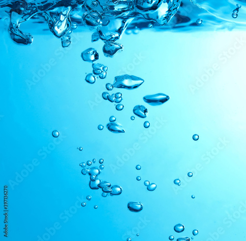 Pouring made a splash of blue waves under the water and Bubbles flowing up on water surface in nature. with copy space photo