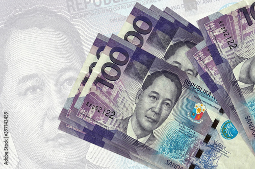 100 Philippine piso bills lies in stack on background of big semi-transparent banknote. Abstract presentation of national currency photo