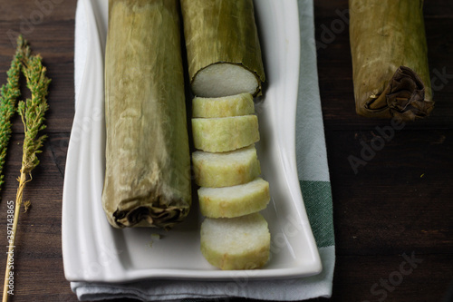 Lontong or boiled rice cake, Indonesian popular rice cake wrapped with banana leaves,  usually eat with chicken or beef satay. Served on ceramic white plate. 
 photo