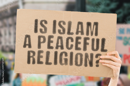 Obraz na plátně The question  Is a peaceful religion?  on a banner in men's hand with blurred background