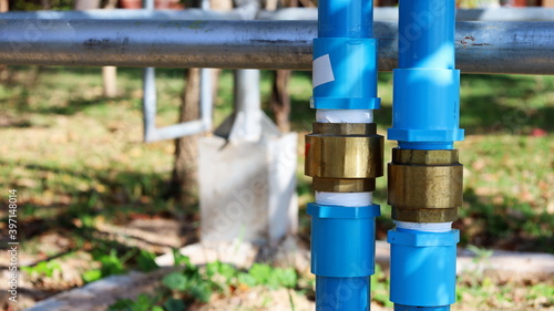 Brass double check valve on PVC pipe. Spring-loaded check valve on the plumbing to regulate one-way flow and prevent reverse flow when the pump stops. Focus closely and choose the subject.