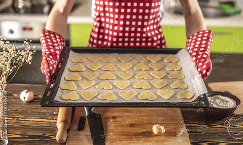 Fotografie Raw homemade cookies in the shape of heart on a baking sheet for baking