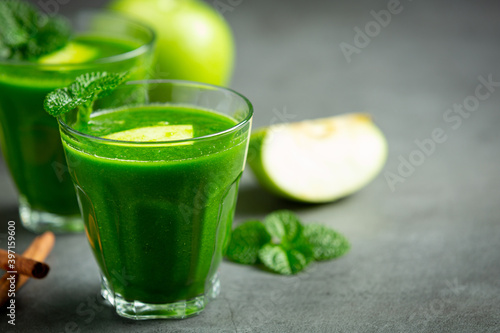 two glasses of green apple healthy smoothie put next to fresh green apples