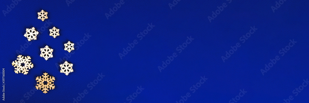 The zero waste new year concept as the handmade wooden snowflakes on the blue background, banner. The zero waste new year concept as the handmade wooden snowflakes on the blue background, banner.