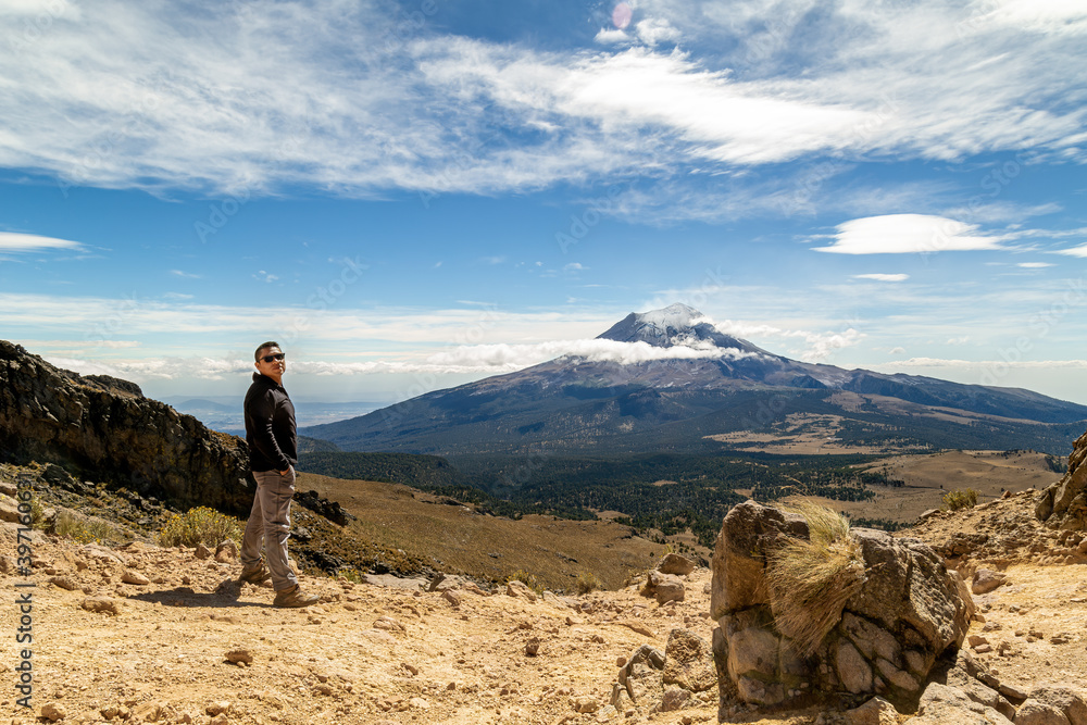 Man reached the top of the mountain.hiker observes the orizonte in the chasm of the Iztaccihuatl volcano Popocatepetl National Park, Mexico. concept Sport and active life