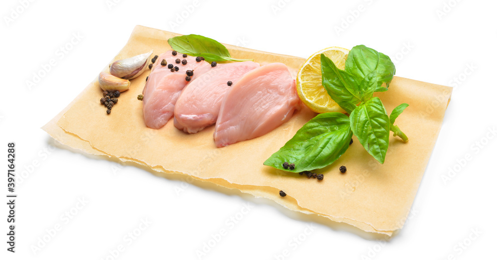 Raw cut chicken fillet with basil and black pepper on white background