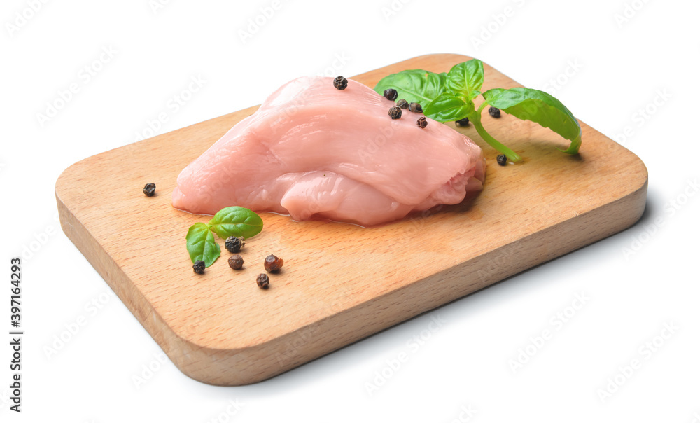 Board with raw chicken fillet, black pepper and basil on white background Board with raw chicken fillet, black pepper and basil on white background