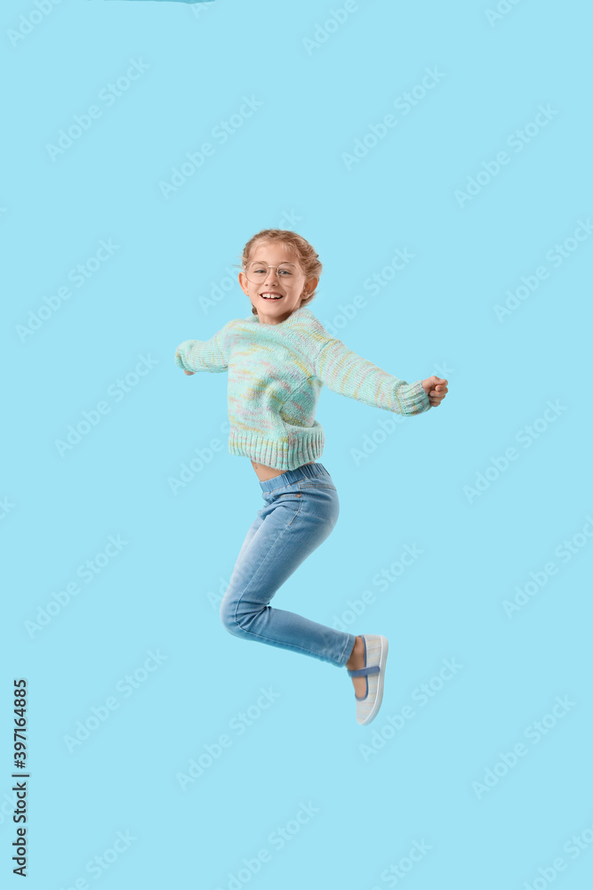 Jumping little girl on color background