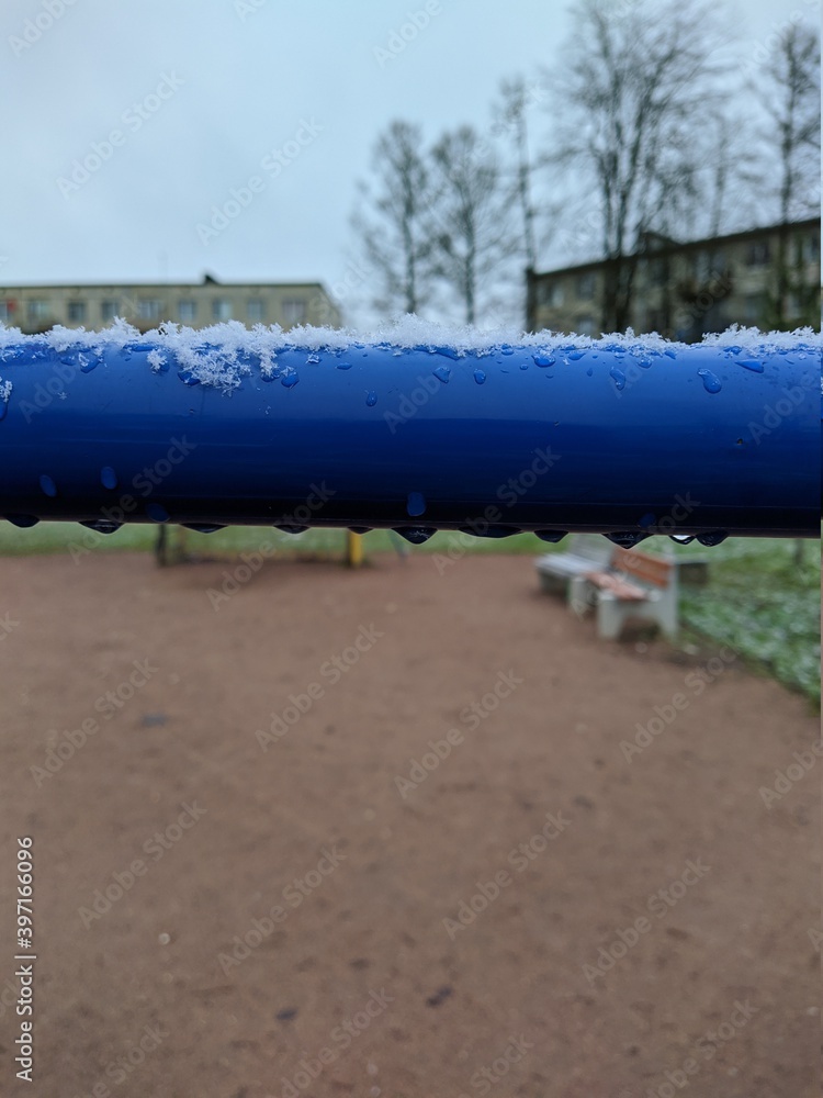 frozen small water droplets on blue metal pipe and blurred background