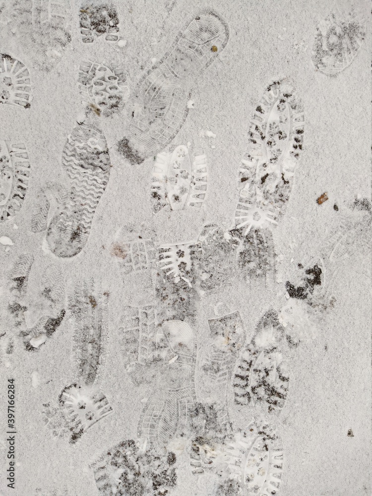 many footprints in the snow during the day