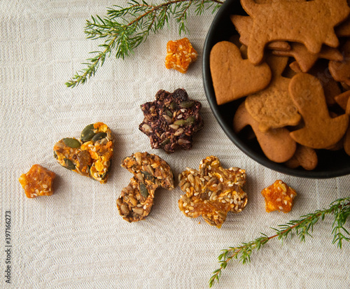 Beautiful christmas gingerbread and cookies from seeds and nuts on white linen background. Tasty, vegan, organic, handmade holiday food. photo