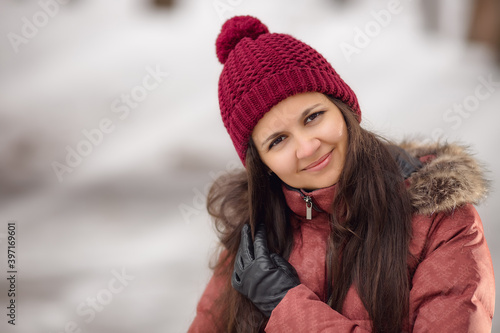Winter portrait of a woman in red hat. Christmas time. Snowdrift, cold. Happy new year. Winter holidays in the city with snow