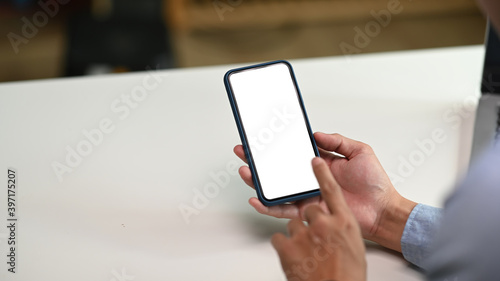 Close up view of male hands using smartphone with blank screen for graphics display montage. © Prathankarnpap