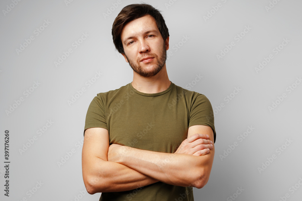 Portrait of a serious pensive young man against grey background Portrait of a serious pensive young man against grey background