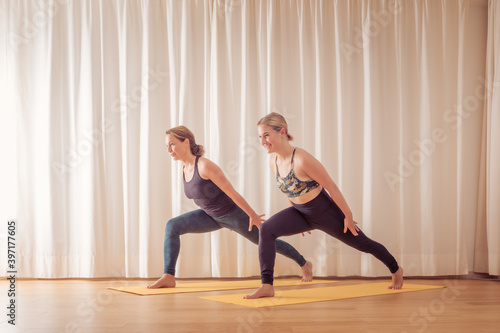 two women doing yoga at home