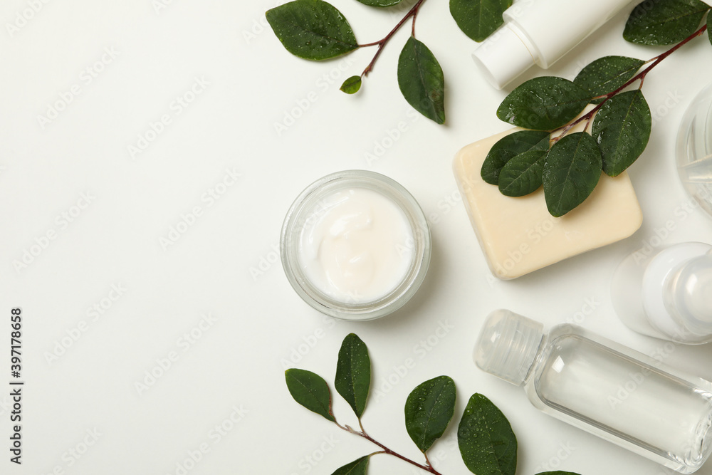 Spa cosmetic products and branches with leaves on white background, top view Spa cosmetic products and branches with leaves on white background, top view