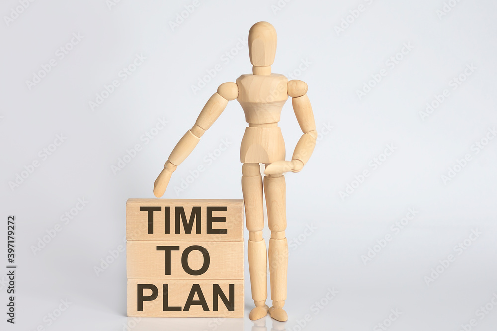 Wooden man shows with a hand text TIME TO PLAN on wooden block Wooden man shows with a hand text TIME TO PLAN on wooden block