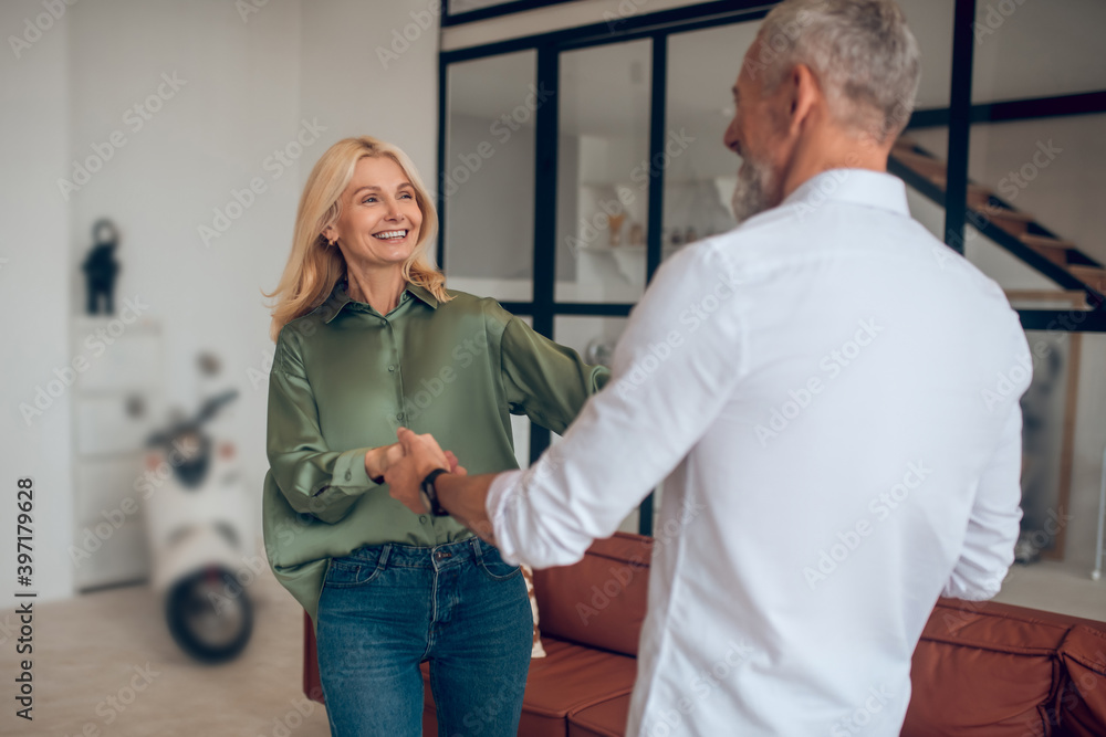 Fototapeta premium Man and woman dancing in the room and looking excited