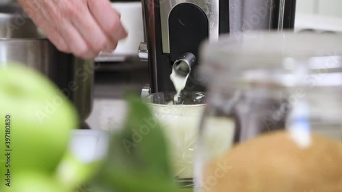 Woman Presses Apple On Juice Extractor In The Kitchen - Fresh Apple Juice. - close up
