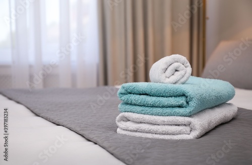 Soft clean towels on bed indoors. Space for text