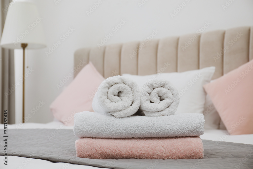 Soft clean towels on bed in room Soft clean towels on bed in room