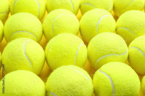 Tennis balls on yellow background, closeup. Sports equipment © New Africa
