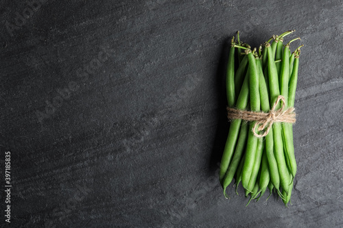 Fresh green beans on black table, top view. Space for text