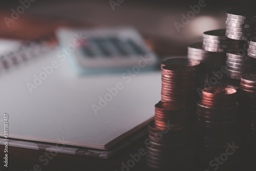 A pile of coins, a large number of books, a calculator Placed on the table.