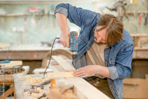 Worker using screwdriver at a workshop