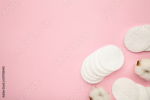 Hygienic disposable product cosmetic pads and cotton flower on pink background