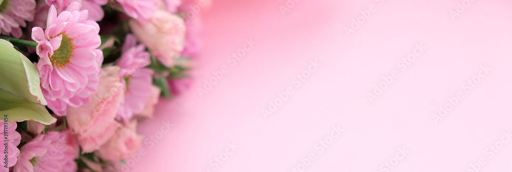 Pink chrysanthemums, orchid and different flowers on pink background.
