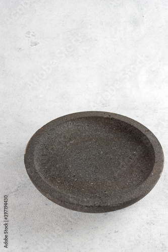 Indonesian traditional seasoning on stone mortar, traditional mash tools or grinder made of stone called 'coet' or 'cobek'
