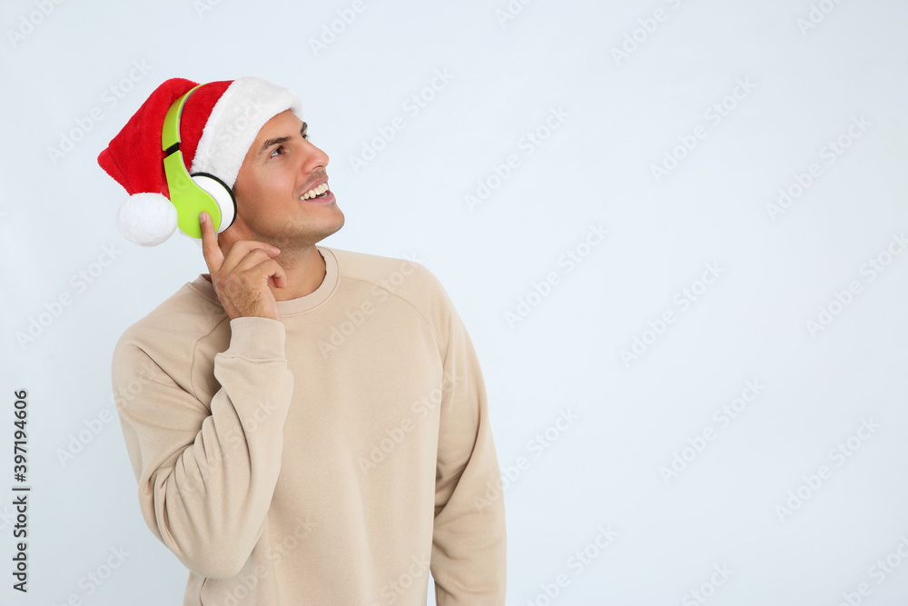 Happy man with headphones on white background, space for text. Christmas music Happy man with headphones on white background, space for text. Christmas music